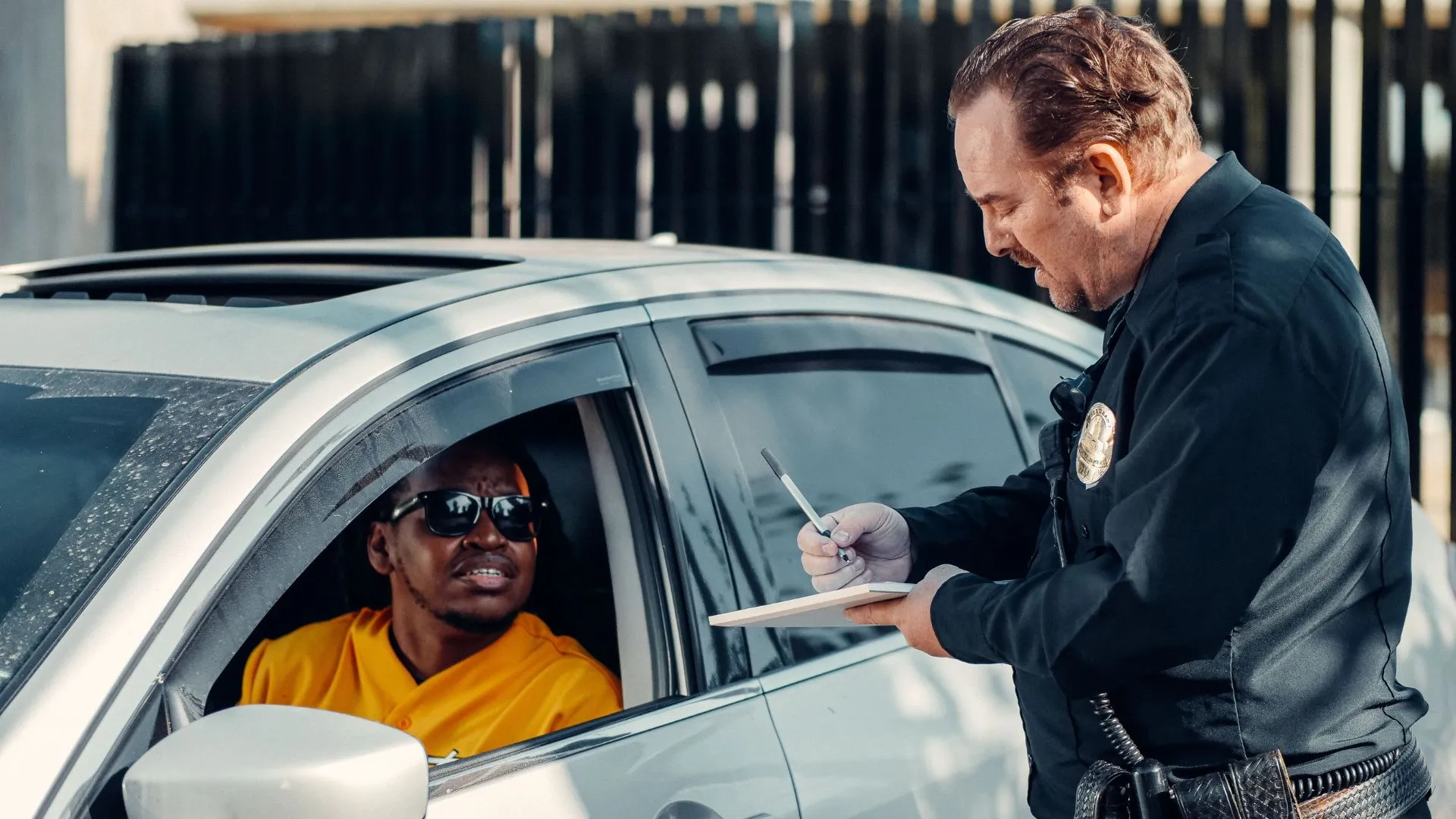  Police officer issuing a traffic ticket during a roadside vehicle stop.